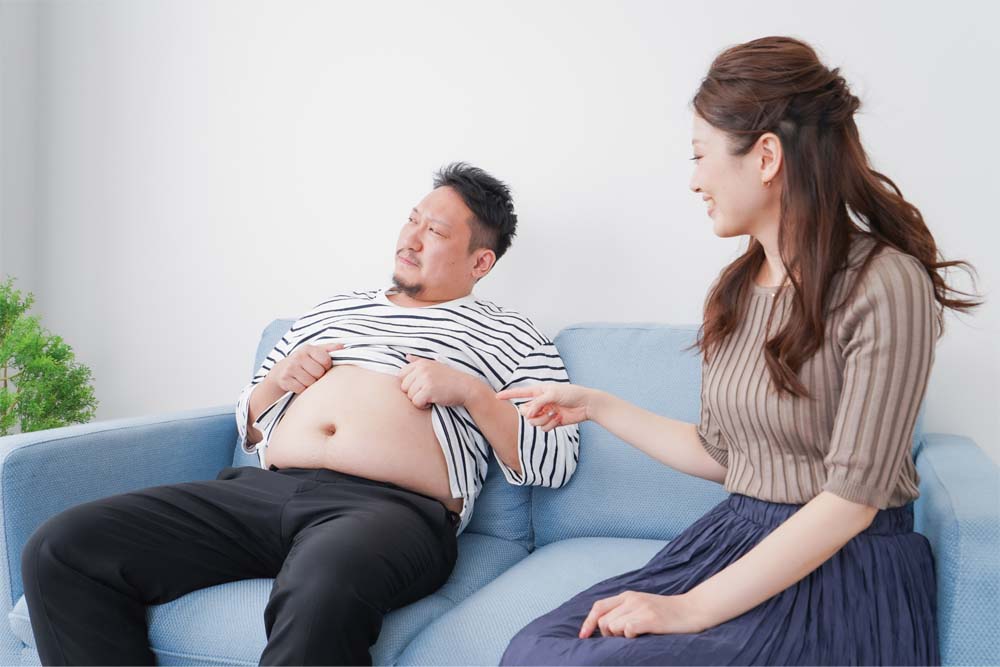正月太りしてお腹を気にする夫婦