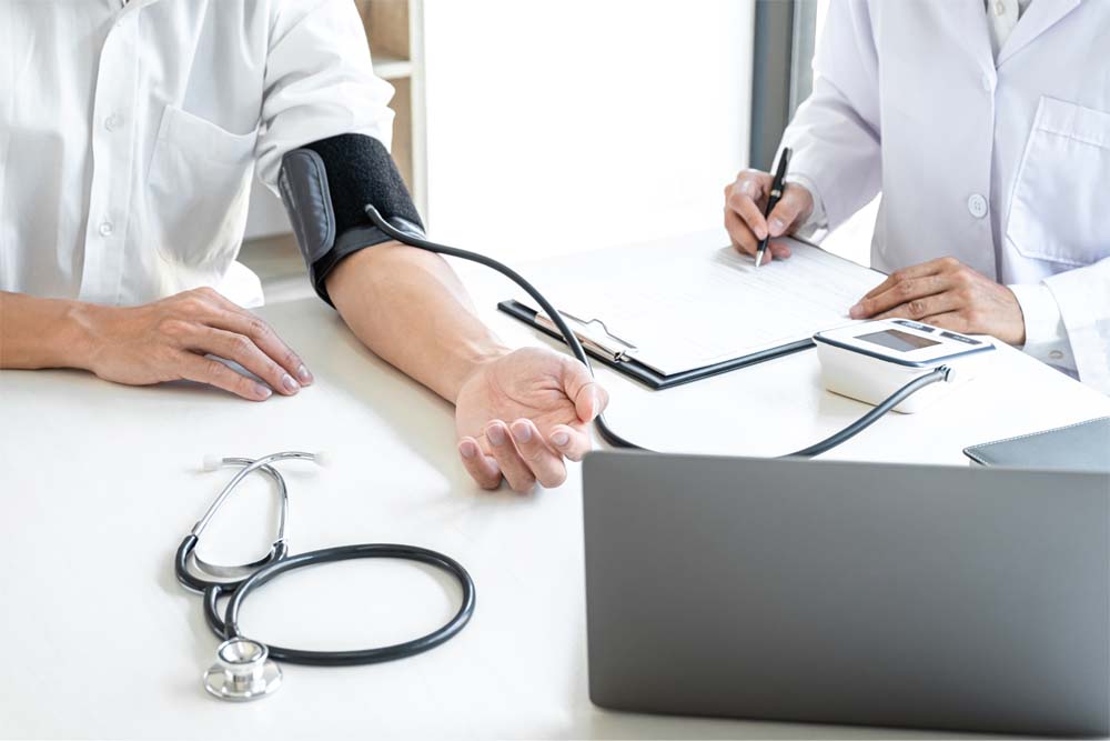 血圧計で血圧を測っている医師とその患者の写真